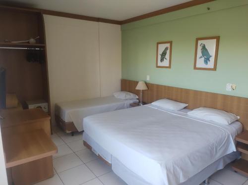 Ένα ή περισσότερα κρεβάτια σε δωμάτιο στο Suítes Golden Dolphin Roberto Imóveis