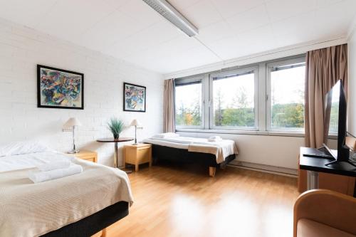 a bedroom with two beds and a large window at Functional and cozy 3 bedroom apartment for 6 in Myyrmäki