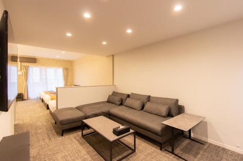 a living room with a couch and a table at Tabi and -light- Hakata01 in Fukuoka