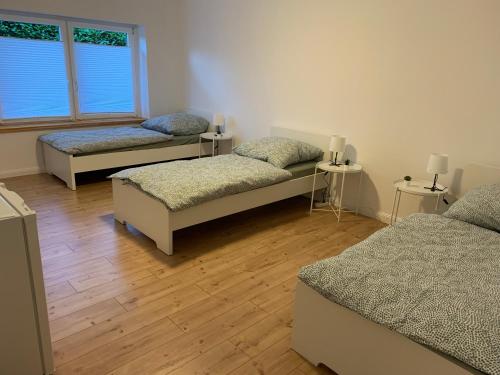 a room with three beds and two windows at Rosengarten UG in Rosengarten