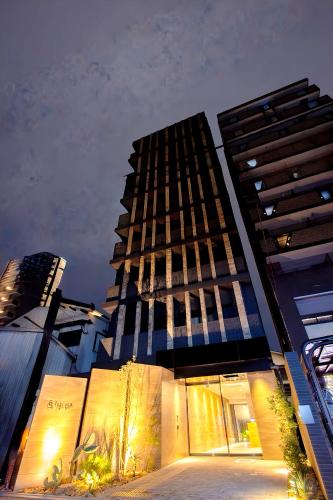 a tall building in a city at night at Tabi and -light- Hakata01 in Fukuoka