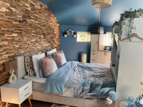 a bedroom with a bed and a brick wall at Van Egmond suites Mr Blue Sky in Anna Paulowna