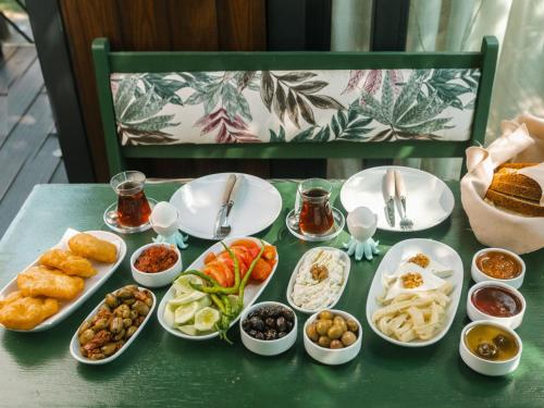 een tafel met borden en kommen met voedsel bij Mona Glamping Caravan Suites in Seferihisar