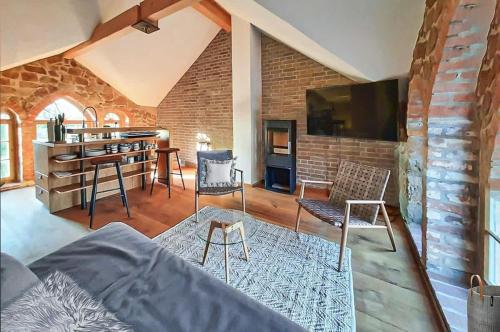 a living room with a bed and a brick wall at HexenburgbeiDresden Architektenwohnung mit Privatsauna, Whirlwanne, Kaminofen und noch viel mehr in Lauterbach