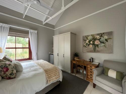 a bedroom with a bed and a desk and a chair at The Courtyard at La Loggia in Nottingham Road