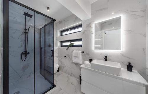 a white bathroom with a shower and a sink at Villa Karla with pool&sea view by Villas Guide in Rab