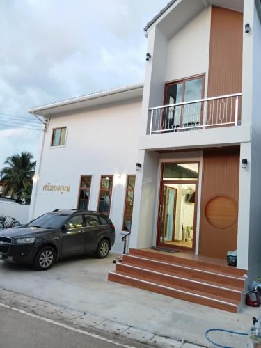 a black car parked in front of a white house at ศรีทองคูณ เชียงคาน ซอย4 in Chiang Khan