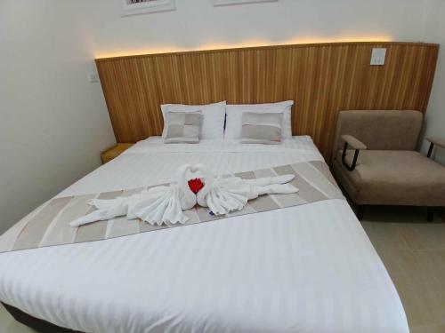 a large white bed with two white towels on it at ศรีทองคูณ เชียงคาน ซอย4 in Chiang Khan