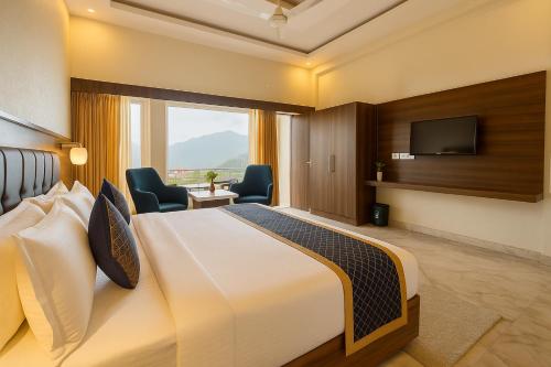 Una habitación de hotel con una cama y un televisor de pantalla plana. en River Grand Hotel - Best Property of Mussoorie 2024-25, en Mussoorie