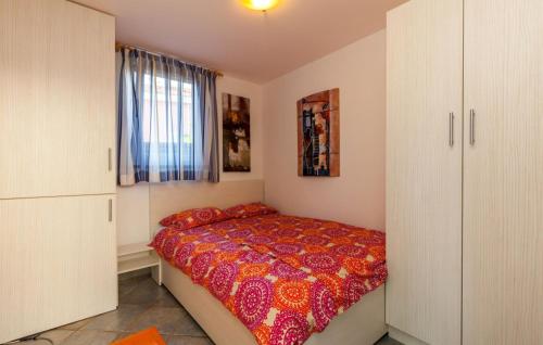 a bedroom with a bed with a red comforter at Ferienhaus Nina mit Whirpool by Villas Guide in Selce