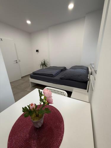 a room with a bed and a table with flowers on it at Schönes Zimmer-1 in Stuttgart-Mitte in Stuttgart