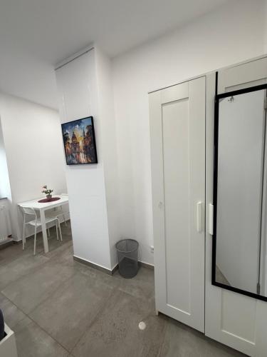 a white room with a table and a white cabinet at Schönes Zimmer-1 in Stuttgart-Mitte in Stuttgart