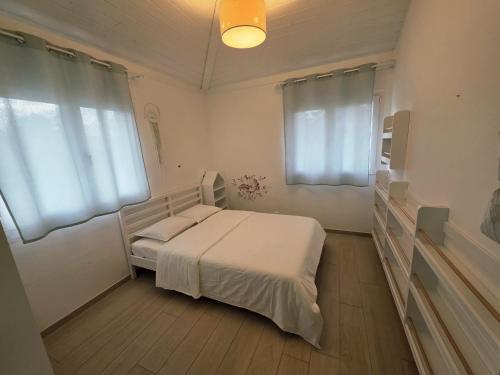 a bedroom with a bed with white sheets and windows at Charming family villa in Geneva