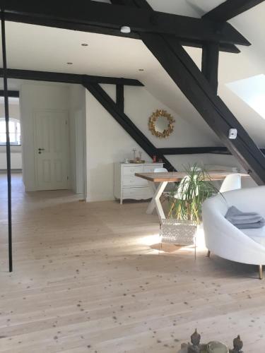 a living room with a white couch and a table at Historisches Designer Loft Nähe Waldorfer Höfe in Ochtendung