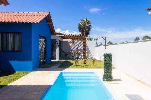 a villa with a swimming pool and a house at Chalé 3 Reis Bg in Barra Grande