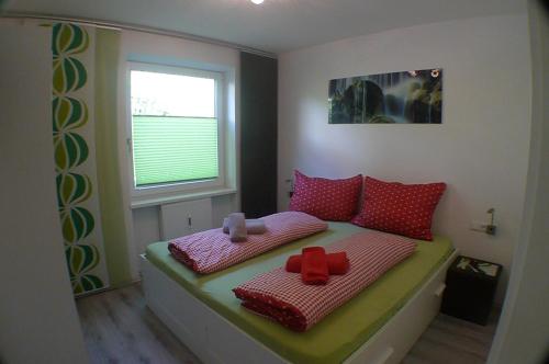 a small bedroom with a bed with red pillows at Apartment Edith Top 1 in Saalbach Hinterglemm