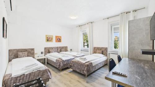 ルートヴィヒスブルクにあるシティ ホテルのベッド2台とテーブルのある部屋