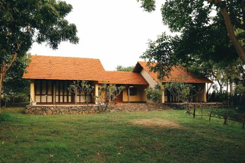a house with an orange roof in a yard at Panai Adi Boutique Villa in Kuravankudil
