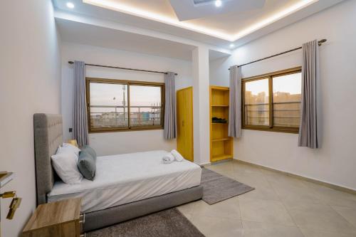 een slaapkamer met een bed en twee ramen bij Residence Fakir in Dakhla