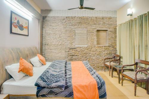 a bedroom with a bed and a brick wall at Kasauli Residency in Kasauli