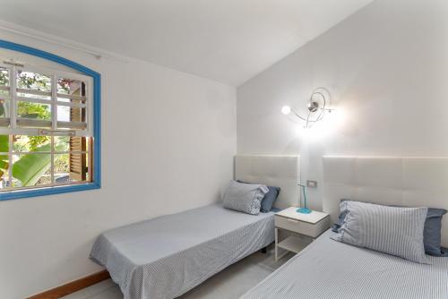 マスパロマスにあるWonderful Bungalow in Maspalomasのベッド2台と窓のある寝室