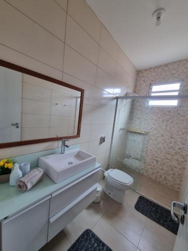 a bathroom with a sink and a toilet and a mirror at Apartment 202 Farol de Santa Marta in Laguna