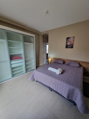a bedroom with a purple bed in a room at Apartment 202 Farol de Santa Marta in Laguna