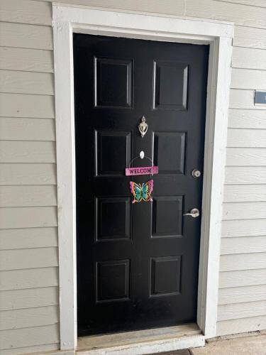 a black door with a butterfly sign on it at Quaint one bedroom flat in Atlanta