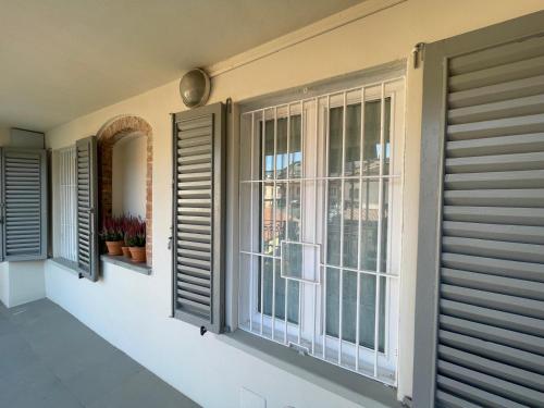 a room with windows and shutters on the wall at Rota's House in Bergamo