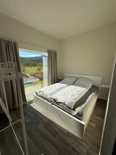a bedroom with a bed and a large window at Apartment in Målselv in Björklid