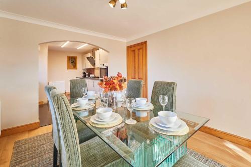 a dining room with a glass table and chairs at Host & Stay - Cherry Willows in Stainsacre