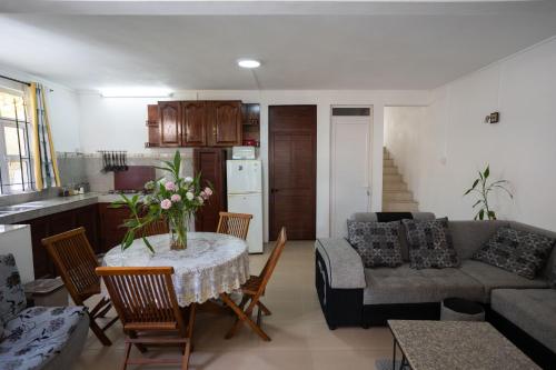 a kitchen and a living room with a table and a couch at Spacious Coastal Home Steps from the Beach in Flic-en-Flac