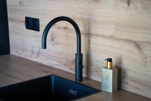 a kitchen sink with a faucet and a soap bottle at Wellness De Thijmse Berg in Rhenen