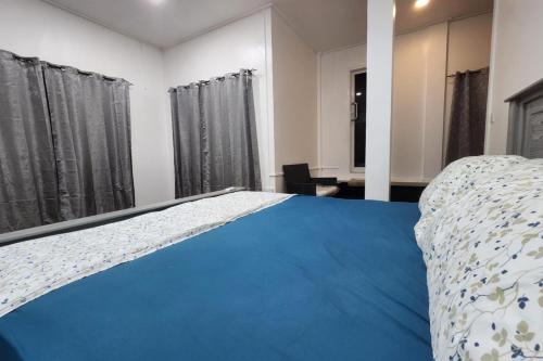 a bedroom with a bed with a blue comforter at 5 Bed Villa Sleeps 10 with Jacuzzi in Georgetown
