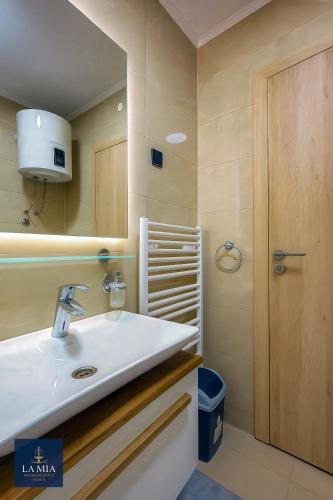 a bathroom with a sink and a mirror at La Mia Premium Suite in Tuzla