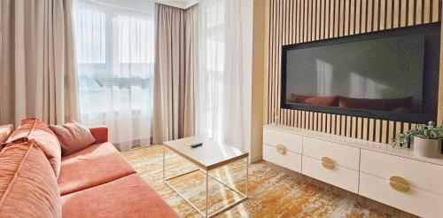 un salon avec un canapé et une télévision à écran plat dans l'établissement HolidayHomePL Bel Mare F402 z balkonem, à Międzyzdroje