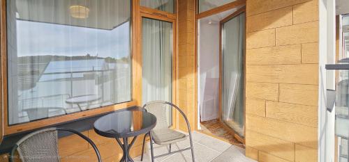 d'un balcon avec deux chaises, une table et une fenêtre. dans l'établissement HolidayHomePL Bel Mare F402 z balkonem, à Międzyzdroje