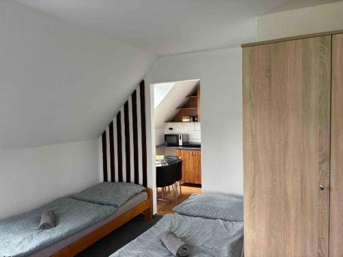 a bedroom with two beds and a kitchen with a table at Sport centrum na hřišti in Golčŭv Jeníkov