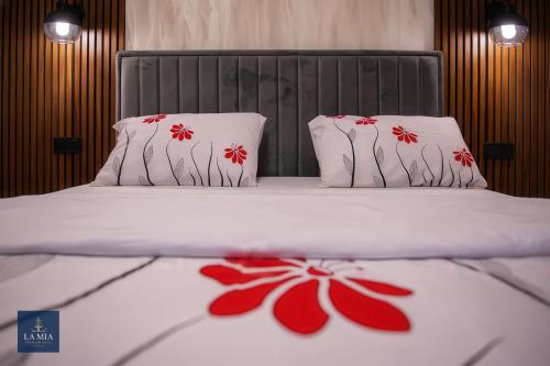 een slaapkamer met een bed met rode bloemen erop bij La Mia Premium Suite in Tuzla