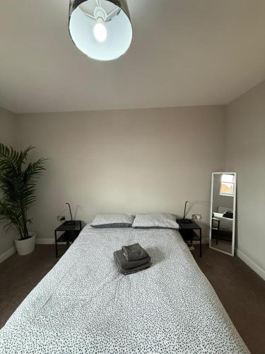a white bedroom with a bed with a purse on it at Leamington Spa Apartments in Leamington Spa