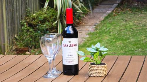 a bottle of wine and a glass on a wooden table at White Cliff Rest in Seaford