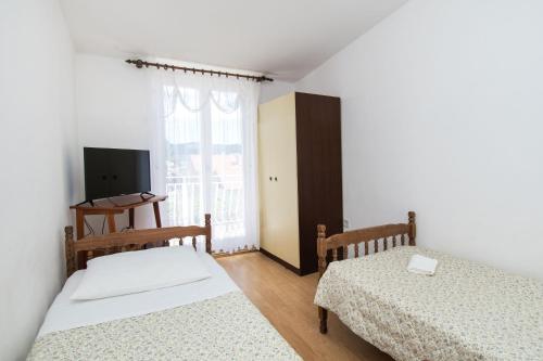 a bedroom with two beds and a window at Apartments Holiday Žaborić in Zaboric