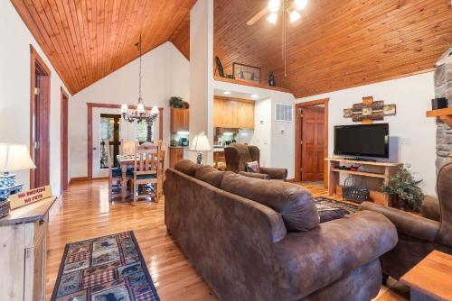 a living room with a couch and a television at Creekside - 2 BDR Resort Cabin in Epic Location in Branson West