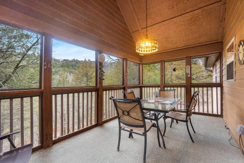 a dining room with a table and chairs on a balcony at Creekside - 2 BDR Resort Cabin in Epic Location in Branson West