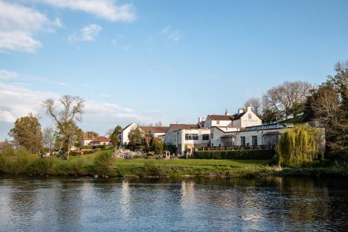 a group of houses next to a river at George of Piercebridge in Piercebridge