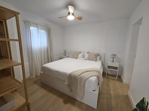 a white bedroom with a bed and a ceiling fan at Gardel Esencia in Icod de los Vinos