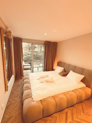 een groot bed in een kamer met een groot raam bij Elysia Room - Évasion, Balnéo et Sauna in Collioure