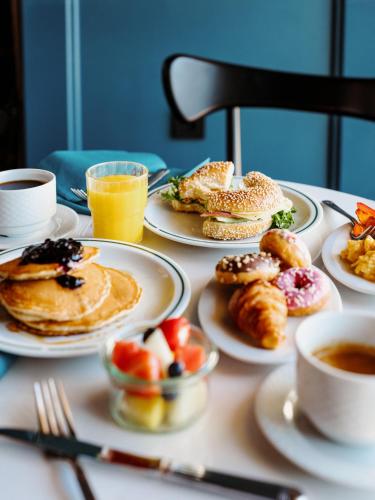Una mesa cubierta con platos de desayuno y bebidas. en Amerikalinjen, en Oslo