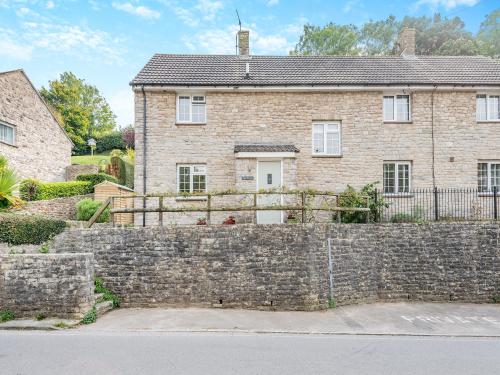 a brick house with a stone wall at The Retreat Lulworth in West Lulworth