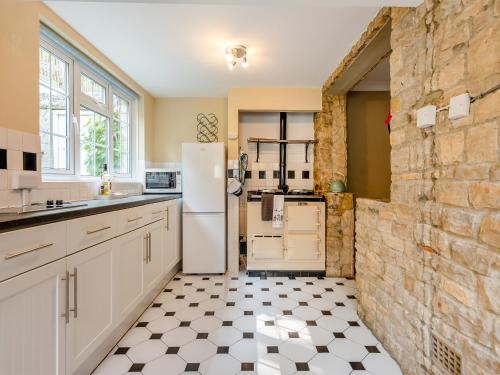 a kitchen with a white refrigerator and a tile floor at The Retreat Lulworth in West Lulworth